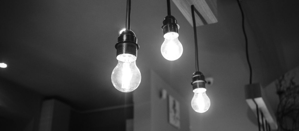 Lightbulbs on and hanging from ceiling in house