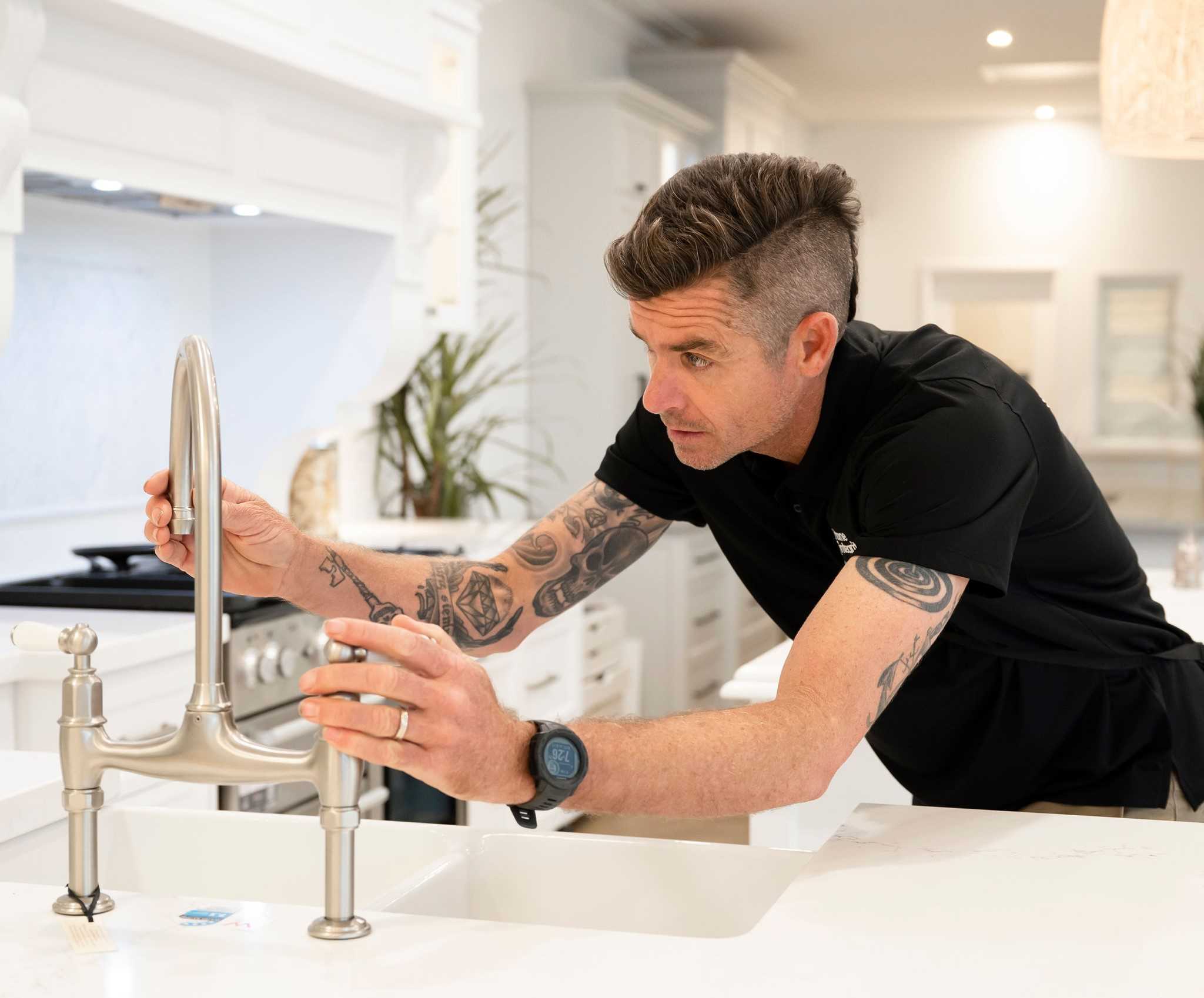 Male inspector looking at kitchen sink and tap functionality